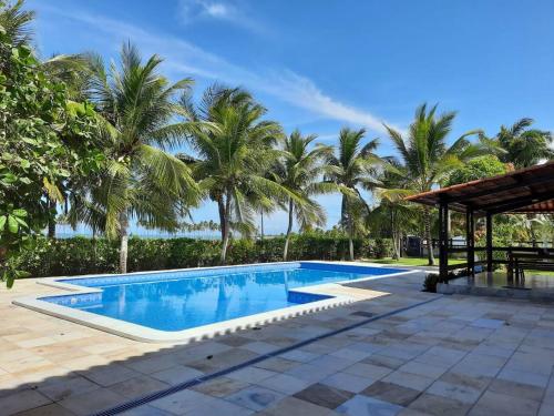 een zwembad in een resort met palmbomen bij Casa do paiva in Cabo de Santo Agostinho