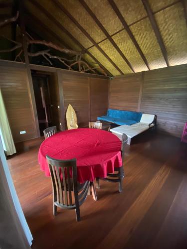 a dining room with a red table and chairs at Chalet Mahina in Mahina