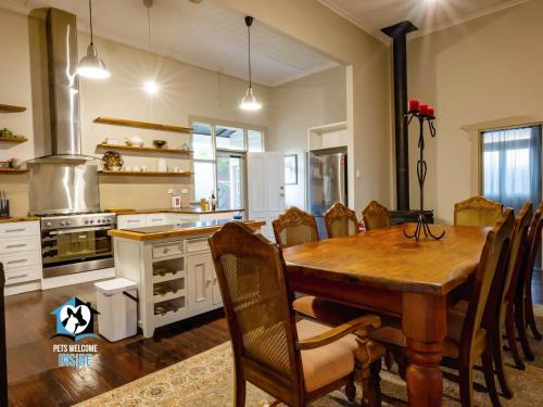 a kitchen with a wooden table and a dining room at The Graeme Addis Homestead in Kalgoorlie