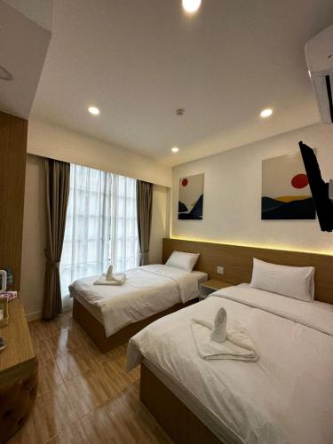 a hotel room with two beds and a window at Midnight Blue Guesthouse in Luang Prabang