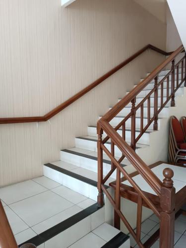 a wooden staircase in a building with a chair at Shafira Hotel Yogyakarta in Ngabean