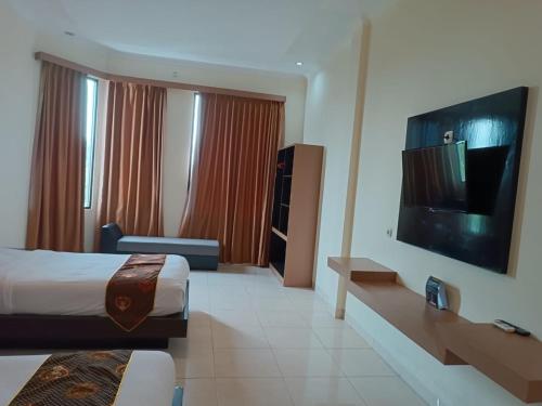 a hotel room with a bed and a flat screen tv at Shafira Hotel Yogyakarta in Ngabean