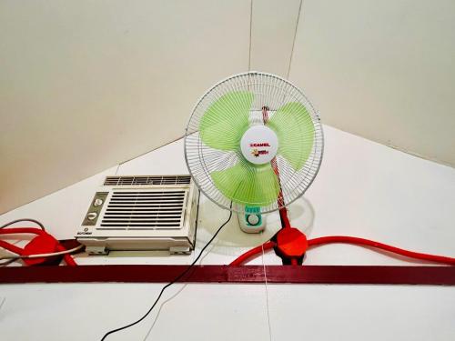 a white fan sitting on a floor next to a heater at Sunnyside Moalboal - 써니사이드 모알보알 게스트 하우스 in Moalboal