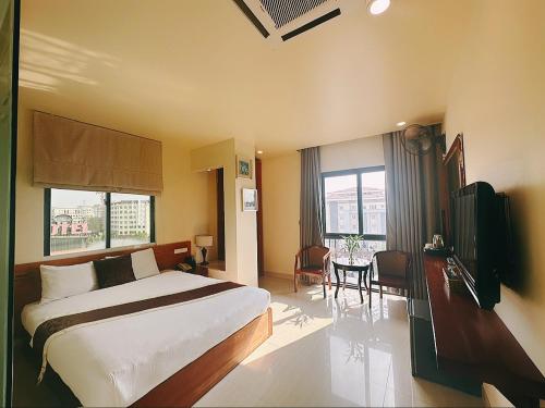 a bedroom with a bed and a table and a television at Hanoi B Hotel & Travel - 5 mins Hoan Kiem lake in Hanoi
