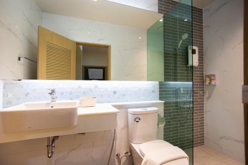 uma casa de banho com um lavatório, um WC e um espelho. em PS23 Residence em Hat Yai
