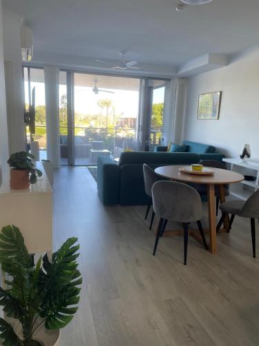 a living room with a blue couch and a table at Signature Waterfront Apartments in Gold Coast