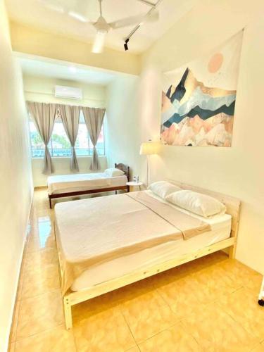 a bedroom with two beds and a painting on the wall at 暖居Mersing Muji Cottage 0.3km Jeti Mersing Centre in Mersing