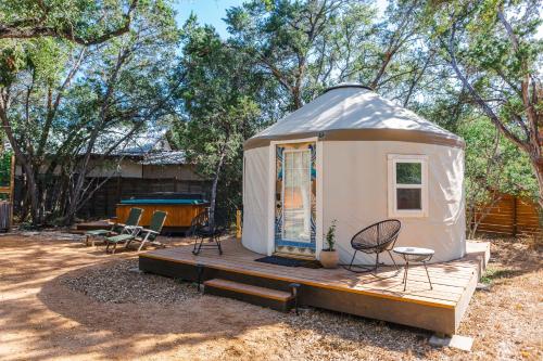 a yurt with a deck and a table and chairs at Camposanto Glamping - The Peacock Yurt in Austin