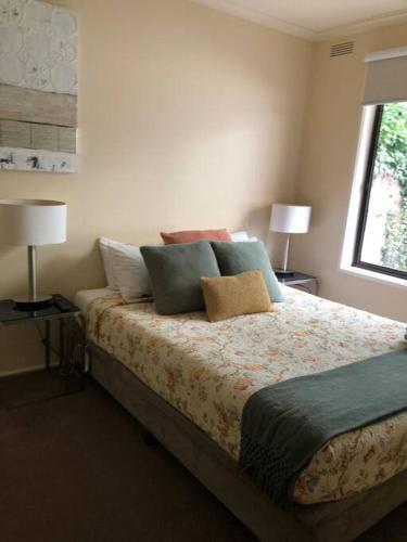 a bedroom with a bed with pillows and a window at Lake Apartment in Wendouree