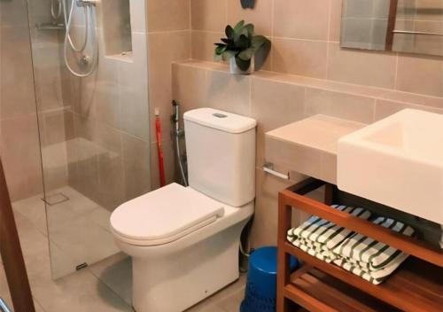 a bathroom with a toilet and a shower and a sink at Timurbay Seafront Residence & Suites in Kuantan