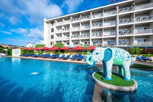 a swimming pool with an elephant statue in front of a hotel at Ramada by Wyndham Phuket Deevana in Patong Beach