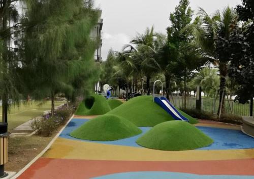 a playground with green grass and a slide at Timurbay Seafront Residence & Suites in Kuantan