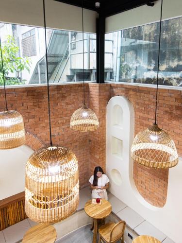 a woman sitting at a table in a restaurant with chandeliers at PS23 Residence in Hat Yai