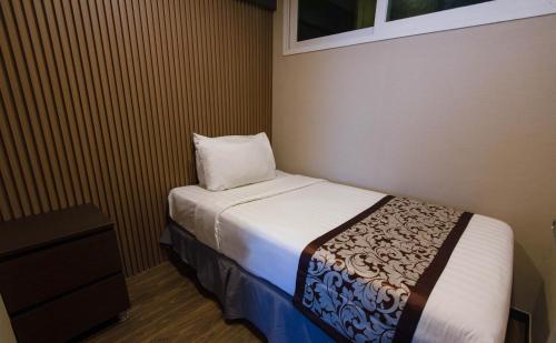 a small bedroom with a bed and a pillow at Xenia Hotel Clark in Clark