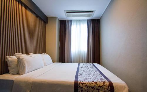 1 dormitorio con 1 cama grande y ventana en Xenia Hotel Clark, en Clark