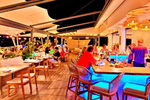 un groupe de personnes assises à table dans un restaurant dans l'établissement Brand New Luxury Private Pool Villa Amber - 5 mins walk to #Sapphire Beach, à East End