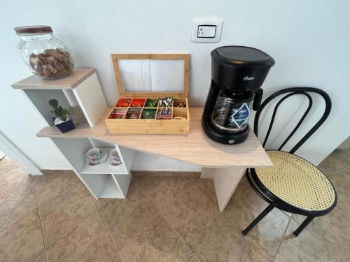 uma máquina de café sentada numa mesa com uma cadeira em HOSTAL - Casa Rionegro -10 min del aeropuerto em Rionegro