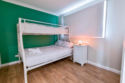 Etagenbett in einem Zimmer mit grüner Wand in der Unterkunft Newly Built Guest House Walk to Lake in Toukley