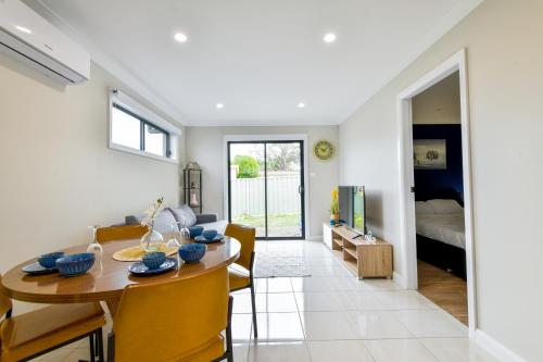 ein Esszimmer und ein Wohnzimmer mit einem Tisch und Stühlen in der Unterkunft Newly Built Guest House Walk to Lake in Toukley