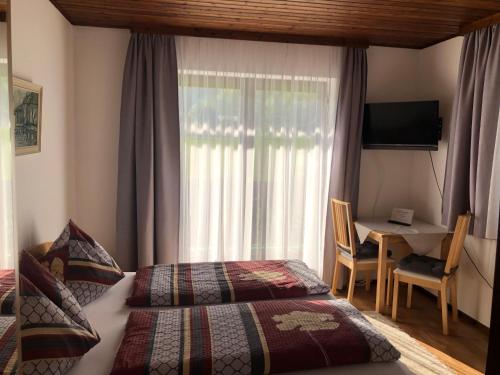 a bedroom with two beds and a desk and a window at Gästehaus Wasserburger in Kernhof