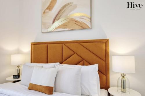 łóżko z drewnianym zagłówkiem i dwoma lampami w obiekcie Ultra Modern 4 Bedroom Villa in Arabian Ranches 2 w Dubaju