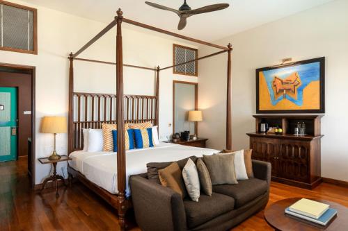 a bedroom with a canopy bed and a couch at Jetwing Lighthouse, A Luxury Reserve in Galle