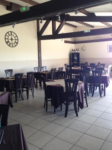 une salle à manger avec des tables et des chaises et une horloge dans l'établissement Le Relais des Bergers, à Saint-Martin-en-Haut