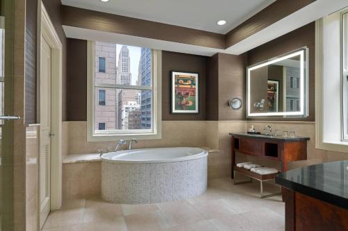 a bathroom with a tub and a sink and a window at JW Marriott Chicago in Chicago