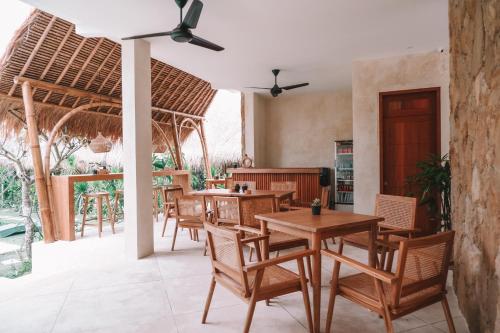 un restaurante con mesas y sillas y un patio en Reset Lombok Hotel, en Kuta Lombok