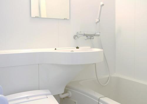 a white bathroom with a sink and a toilet at Hotel Trend Takatsuki in Takatuki