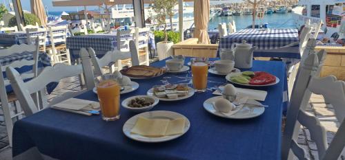 uma mesa azul com pratos de comida e sumo de laranja em Y & P LATCHI HOTEL em Lachi
