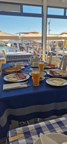 una mesa azul con platos de comida y bebidas. en Y & P LATCHI HOTEL en Lachi