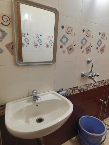 a bathroom with a white sink and a mirror at Flagship La Grande Residencya in Old Goa
