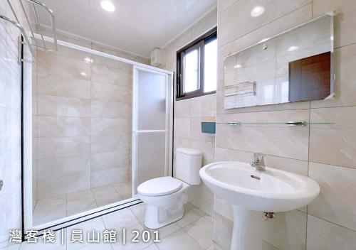 a white bathroom with a toilet and a sink at Yuanshan Dahu Homestay in Yuanshan
