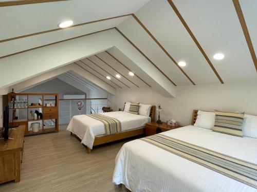 2 łóżka w pokoju na poddaszu w obiekcie Lin Qi in my heart Villa w mieście Dongshi