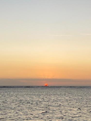 una puesta de sol sobre el océano con el sol en el horizonte en Gili pelangi, en Gili Trawangan