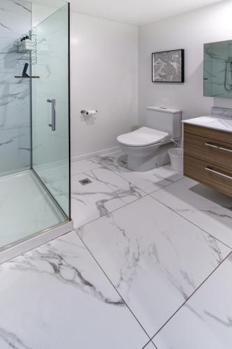 a bathroom with a glass shower and a toilet at Central City Hideout, Location, Location! w/park in Christchurch