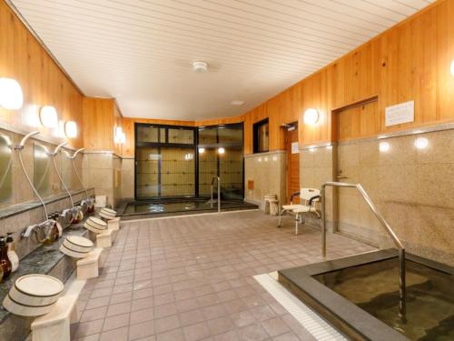 a bathroom with a row of toilets and sinks at Miyazaki Lions Hotel in Miyazaki