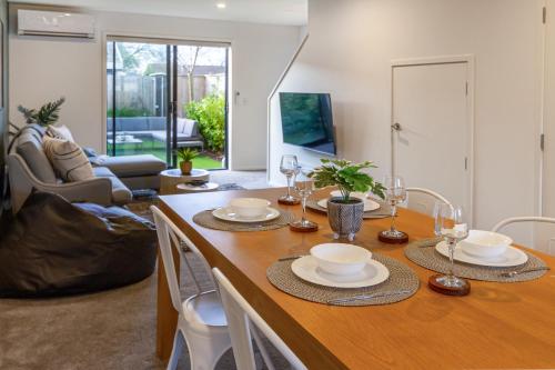 a dining room with a table and chairs and a living room at Central City Hideout, Location, Location! w/park in Christchurch