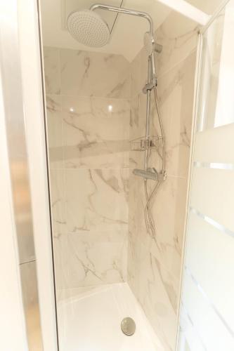 une salle de bain avec une douche avec une porte vitrée dans l'établissement Nice Coastal Studio, à Nice