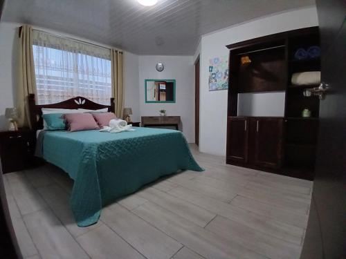 una camera con letto verde e finestra di Ledy's Inn a Turrialba