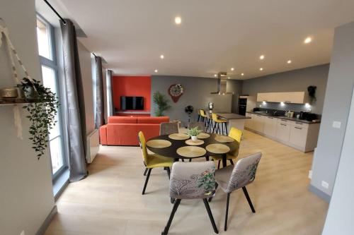 une salle à manger et un salon avec une table et des chaises dans l'établissement Appartement Le palais autun, à Autun