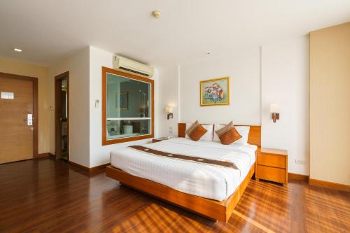 a bedroom with a large bed with a large window at Lantana Resort Hotel Bangkok in Bangkok
