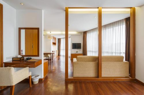 a living room with a couch and a table at Lantana Resort Hotel Bangkok in Bangkok