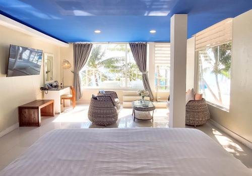 a bedroom with a large bed with a blue ceiling at Boracay Ocean Club Beach Resort in Boracay