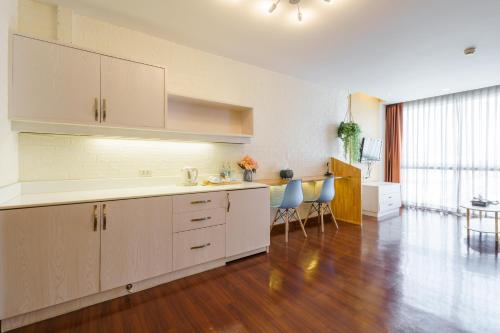 a kitchen with white cabinets and a wooden floor at Lantana Resort Hotel Bangkok in Bangkok
