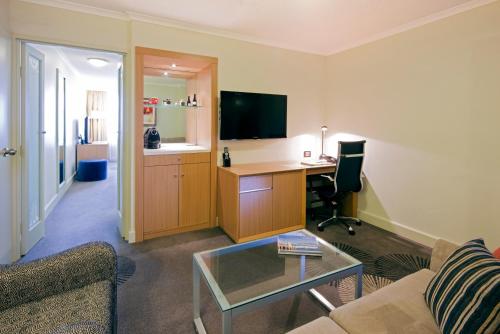 a living room with a couch and a desk at Holiday Inn Parramatta by IHG in Sydney
