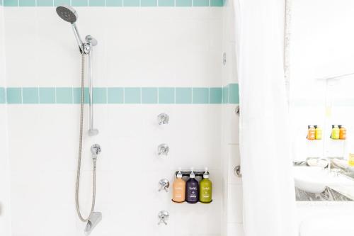 a bathroom with a shower with bottles on the wall at Holiday Inn Parramatta by IHG in Sydney