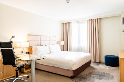a hotel room with a bed and a desk and a chair at Holiday Inn Parramatta by IHG in Sydney