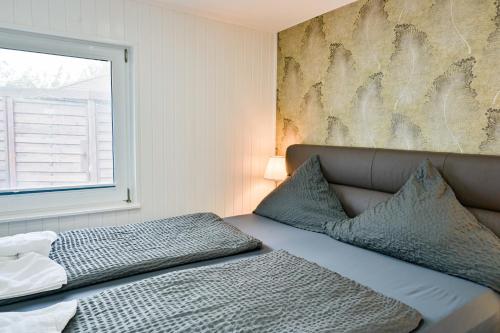 Bett in einem Zimmer mit einem Fenster und einem Bett sidx sidx sidx sidx in der Unterkunft Haus Windhook in Dierhagen